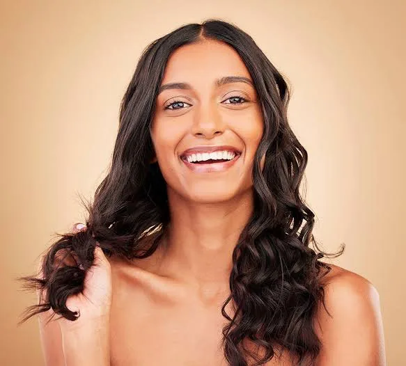 Smiling Indian woman with long, voluminous curly hair